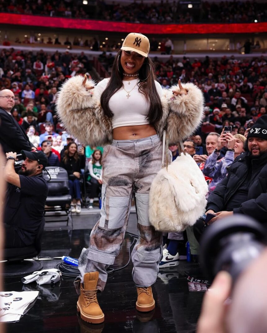 Megan Thee Stallion Attends the Bulls vs Celtics Game in a DSquared Fur Coat, Who Decides War Cargo Pants, and a YSL Niki Oversized Fur Bag