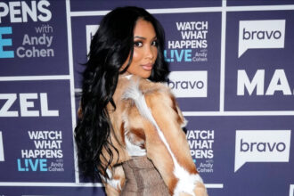 Brit Eady Appeared on WWHL in a Brown Vintage Roberto Cavalli Dress with a Dior Handbag and Christian Louboutin Boots