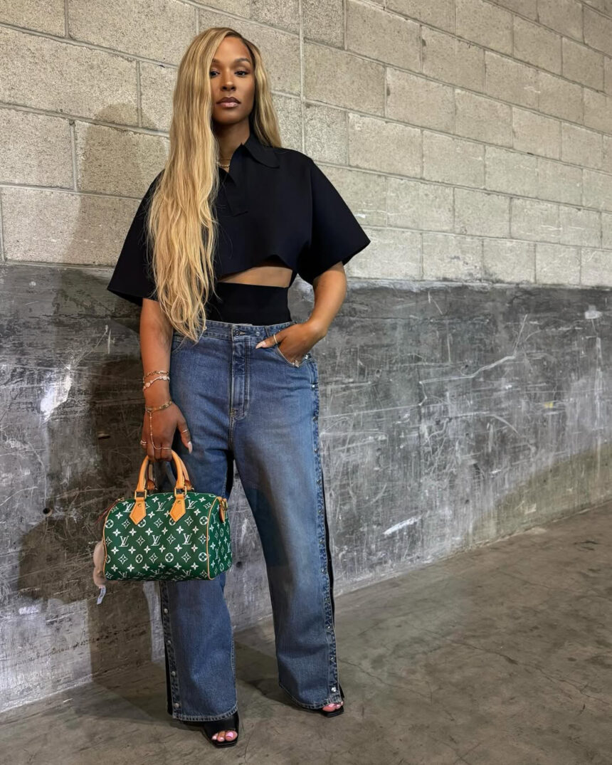 Savannah James Attends Basketball Game Wearing an Alaia Cropped Black Polo Shirt, Snap Denim Jeans, Louis Vuitton Green Speedy, and Bottega Veneta Mules